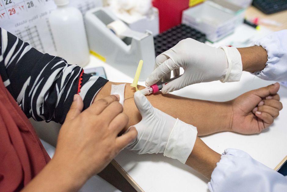 What Is an A1C Blood Test? Normal Range and What Your Result Means - phlebotomist drawing blood